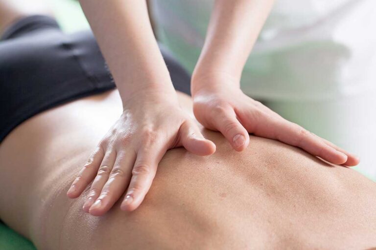 A chiropractor discussing spinal health with a patient in a bright, comfortable clinic setting.