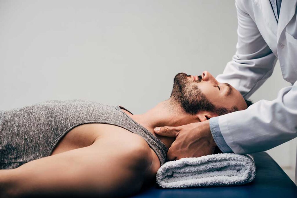 Clinician performing a controlled spinal adjustment with a patient lying on a treatment table.